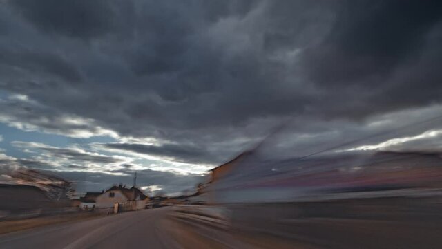A drive on the highway from Prague to Plzen. Dark stormy clouds looming above the highway. Rays of the sun piercing the thick cloud cover.