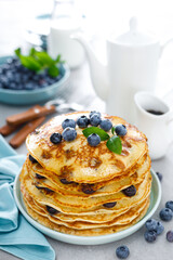 Blueberry pancakes with butter, maple syrup and fresh berries. American breakfast