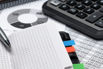 business office desk closeup - financial reports, analysis and accounting, set of documents, tables and graphs, various items for bookkeeping, calculator
