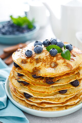 Blueberry pancakes with butter, maple syrup and fresh berries. American breakfast