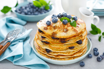 Blueberry pancakes with butter, maple syrup and fresh berries. American breakfast