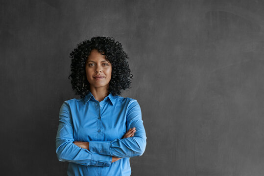 Confident businesswoman smiling in front of a chalkboard