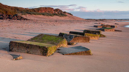 Cresswell Beach, Northumberland, England, UK. In early morning light with WW2 coastal defence...