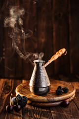 Coffee Turk on a wooden background with fresh hot coffee, steam is coming. next to them are berries as a dessert. beautiful backlight