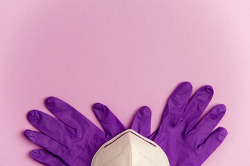 covid-19 concept, protection and hygiene, partial view of mask with gloves, purple background. top view