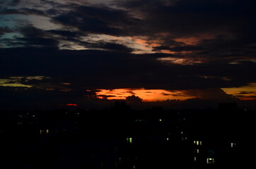 Beautiful and dramatic sky with clouds over the city with a blurred view at Savar, Bangladesh. Blur Background with golden and reddish sunset abstract. sunset in the city with shadows of buildings