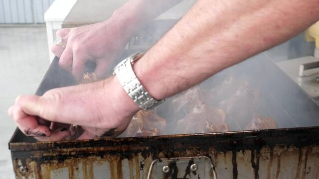 Smoking Poon fish putting back the lit on the smoker