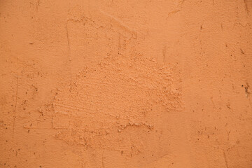 close-up of the clay wall of a terracotta-colored village house, texture