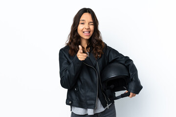 Young woman holding a motorcycle helmet over isolated white background pointing to the front and smiling