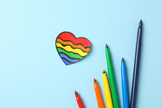 LGBT heart and felt-tip pens on blue background