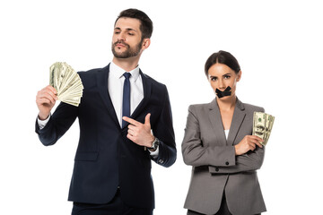 businessman holding dollars near businesswoman with duct tape on mouth standing with crossed arms isolated on white