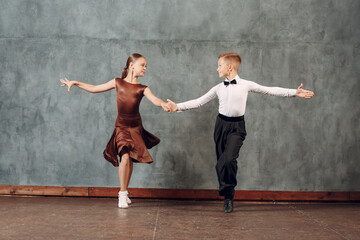 Young dancers boy and girl dancing in ballroom dance Samba. - obrazy, fototapety, plakaty