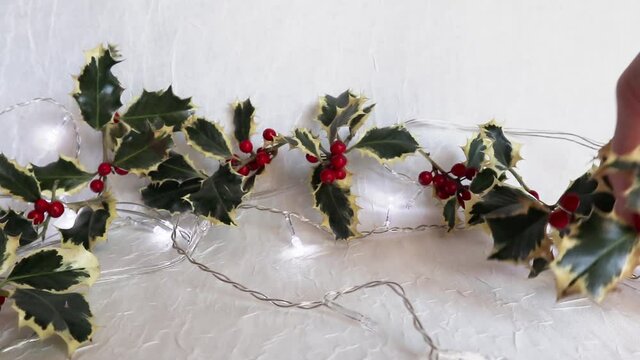 Creating Christmas wreath decorations.
twigs holly and gifts on the background of flashing lights.
Symbolic image. Christmas background. Copy space.