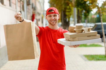 Delivery man is holding goods. Paper bag and fast food containers