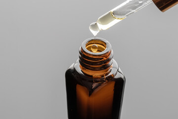 A drop of essential oil beeing dropped into a bottle