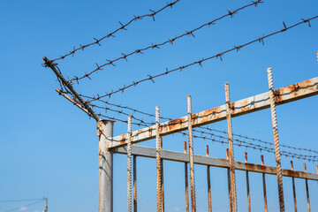 Barbed wire on an old steel fence close up abstract background.