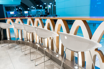 The interior of the waiting room. A row of chairs near the bar shelf.