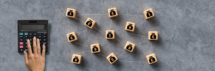 hand over calculator and cubes depicting a money network on concrete background