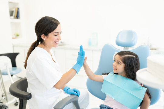 Smiling Dentist And Patient High-Fiving