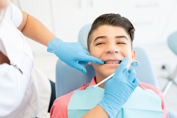 Orthodontist Checking Teeth Of Patient
