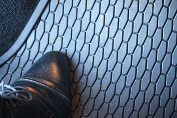 Shoe on a stylish new car mat