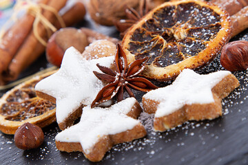 Zimtsterne, Zimtstangen, Orangenscheiben weihnachtlich dekoriert	