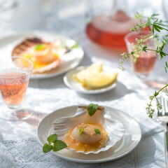Pan Seared Sea Scallops with Orange Tomato Sauce. Glass of Rose Wine