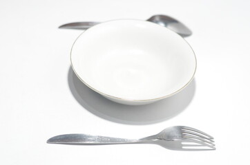 Table Dish with spoon, fork and plate on isolated white background