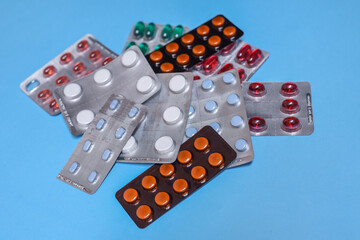 Close up of medicine pill in pack of blisters, pack of medicine pills and capsules on a blue background