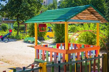 Fototapeta na wymiar Beautiful colored children's gazebo with bird feeder on the playground