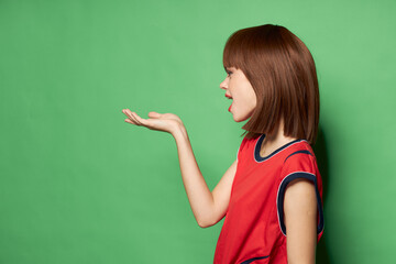 Side view of a beautiful woman in a t-shirt showing her hand 