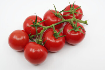 Tomato branch. Tomatoes isolated on a white background. Red tomatoes on a twig on a white background. 
