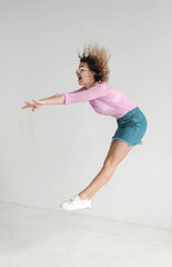 Pretty curly hair dancer on light background. 