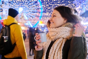 Mature woman with shopping bags and cup of drink at Christmas market