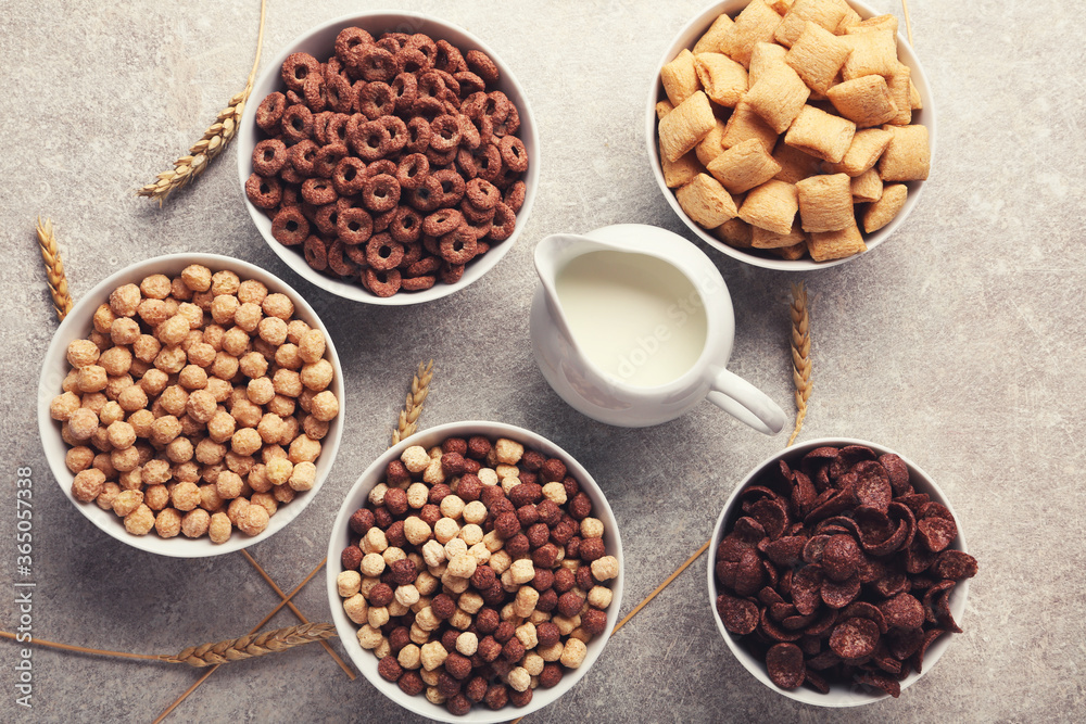 Poster Various corn flakes with milk in jar and wheat ears on grey background