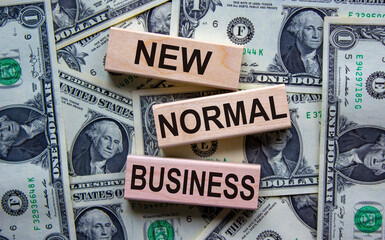 Concept text 'new normal business' on wooden blocks on a beautiful background from dollar bills.
