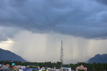 Rain shower falling from dark cumulus clouds