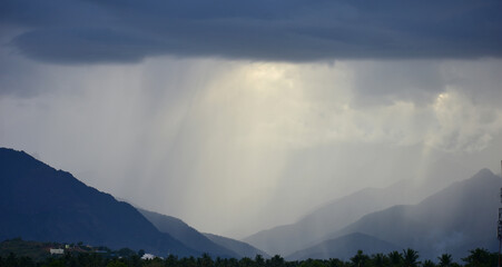 Rain shower falling from dark cumulus clouds