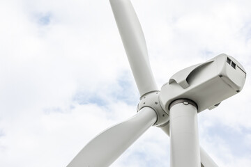 Modern wind turbine against cloudy sky, closeup. Alternative energy source