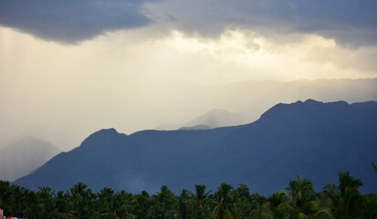Rain shower falling from dark cumulus clouds