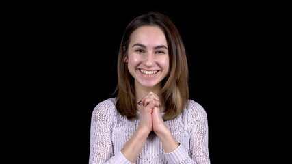 The young woman shows emotions of joy. Woman enthusiastically smiles on a black background