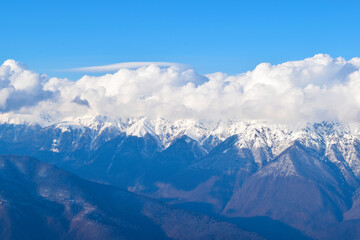 Cumulus clouds flying over a mountain range.