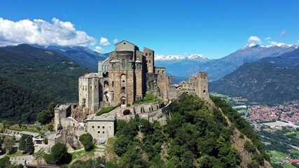 The Sacra di San Michele (Saint Michael's) Abbey, Turin, Italy, shot aerial with mountains of Susa...