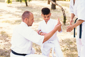 Karate instructor, sensei teaches a child martial arts