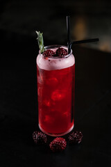 Making cocktails at home like an expert nightclub barman. Fresh and juicy colorful homemade cocktails garnished with berries, orange, mint  on dark background.