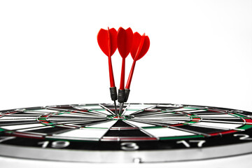 Fototapeta premium Close up shot red dart arrow on center of dartboard, metaphor to target success, winner concept, Isolated on white background with clipping path