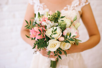 wedding bouquet of flowers in the hands of the bride close-up, white and pink roses, horizontal photo, white wedding dress, place for text, wedding day