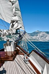 Ocean ​​view from the deck of the sailing yacht. Yacht sailing to the shore on a bright sunny day. Yachting in the sea. Yachting sport. Ocean regatta on sailing yachts. Nautical lifestyle. Freedom.