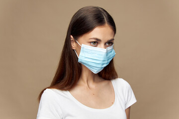 Pretty woman in white shirt in a medical mask 