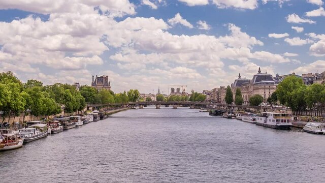 A timelapse along the river Seine with fly boats passing by with motion blur.  Sunny summer day in Paris famous riverside bay view, over hitorical bridge and Notre-Dame de Paris are in sight, zoom in